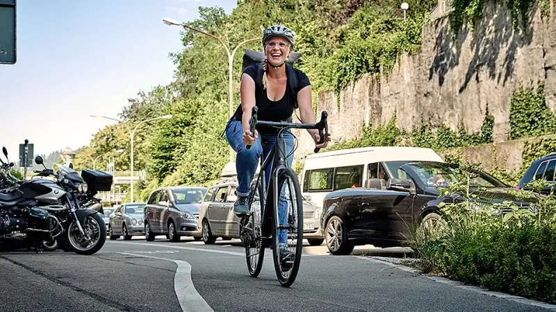Frau fährt mit JobRad am Stau vorbei Frau fährt mit JobRad am Stau vorbei