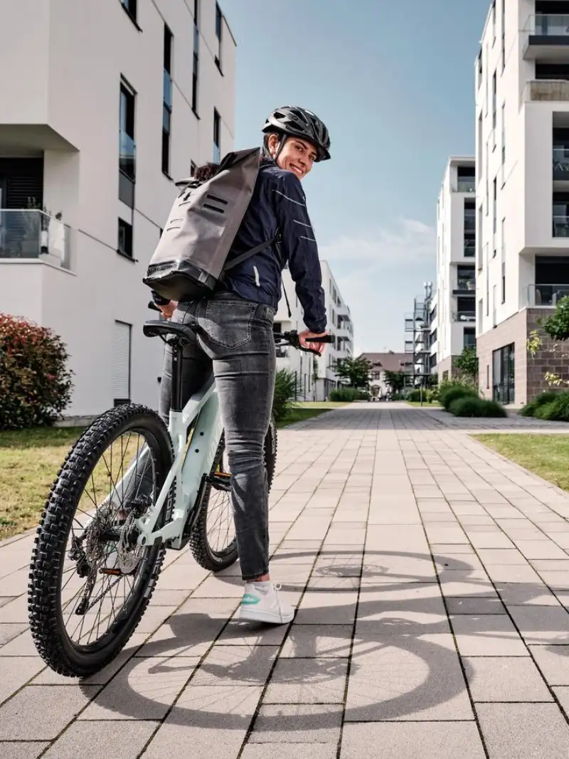 Eine JobRadlerin mit Mountainbike in einer Häuserschlucht Eine JobRadlerin mit Mountainbike in einer Häuserschlucht